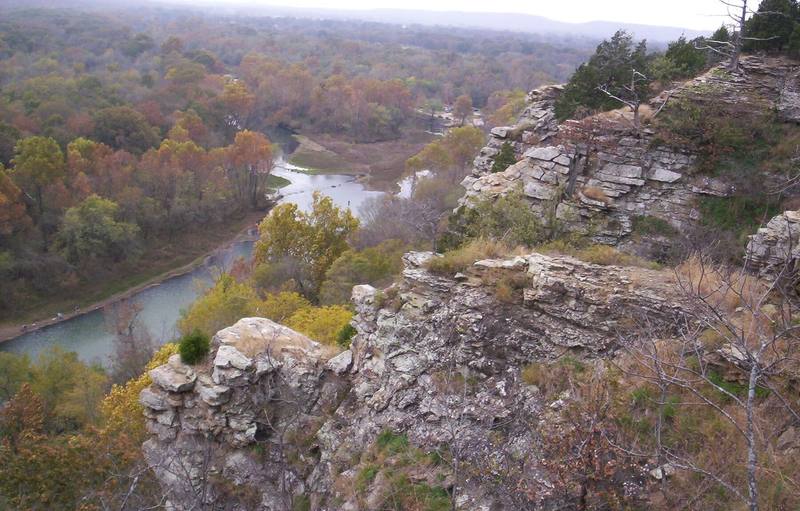 The Illinois River winding through autumn woods below limestone bluffs